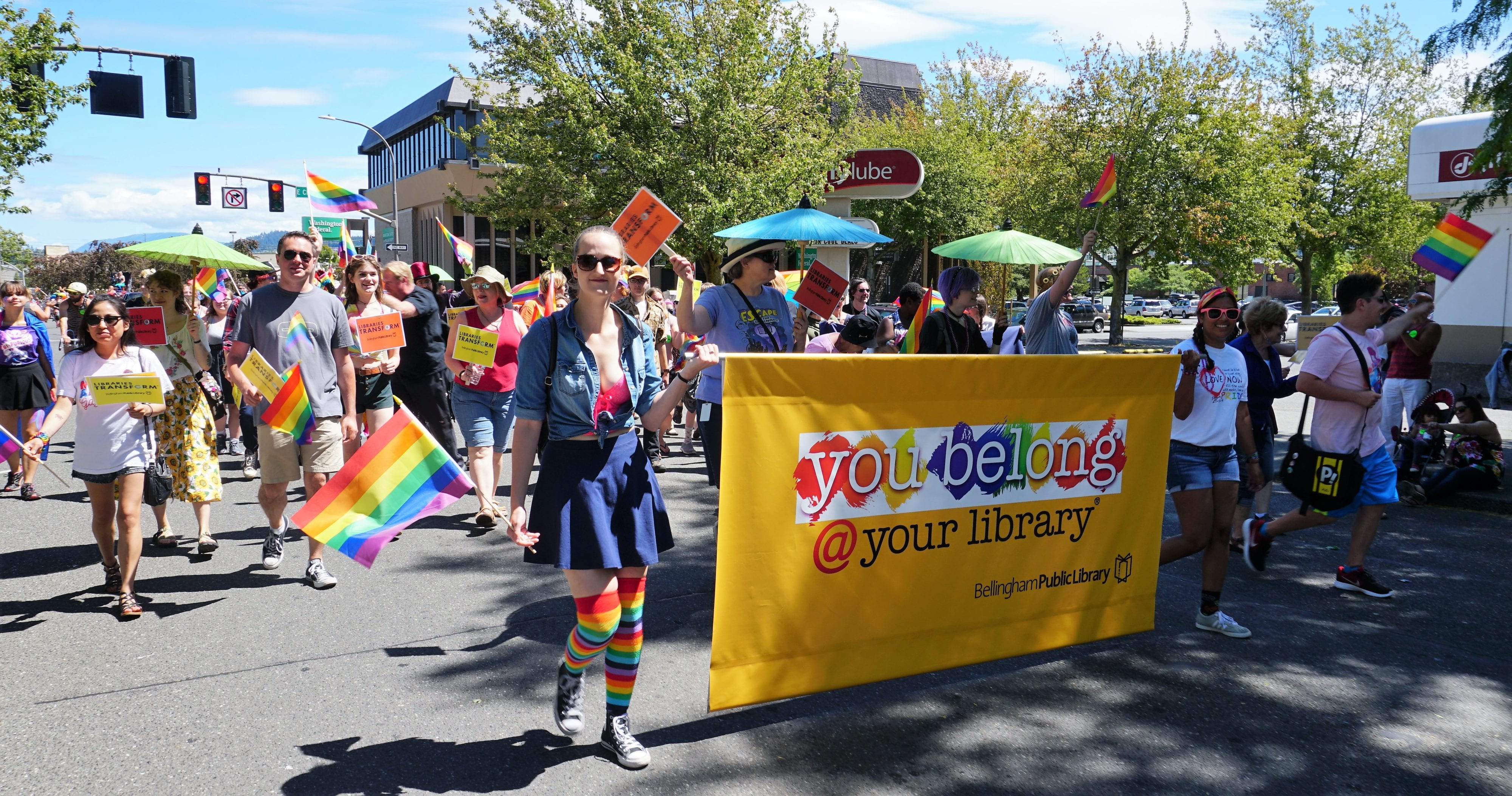 people marching with library banner in Pride Parade