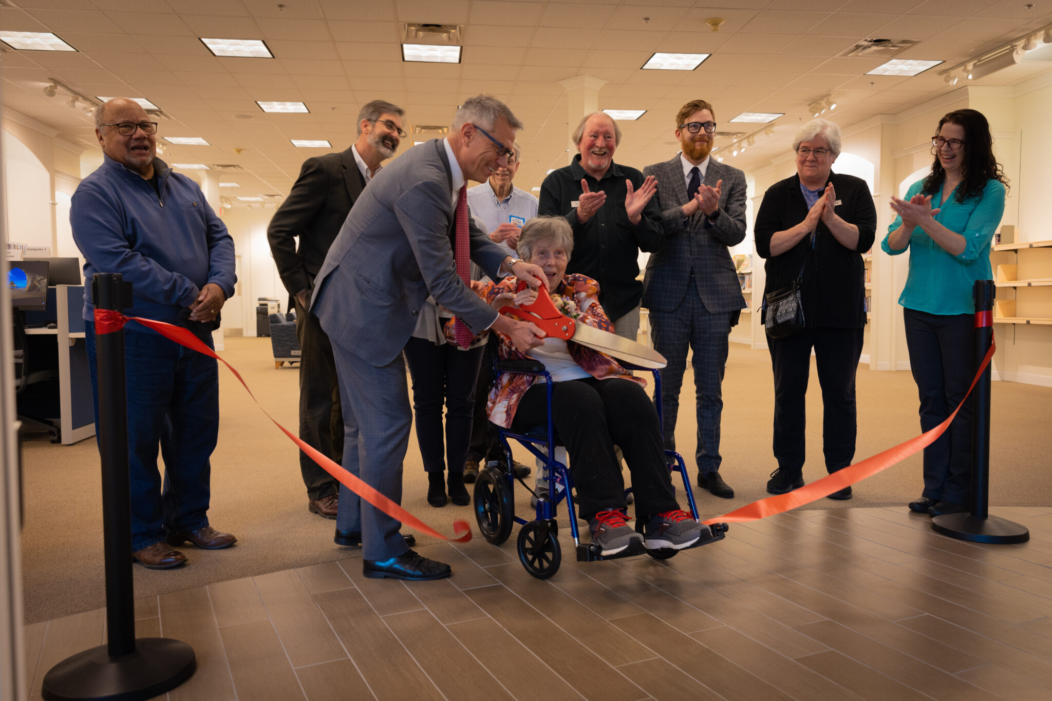 Multiple people cut ribbon for new Library Branch
